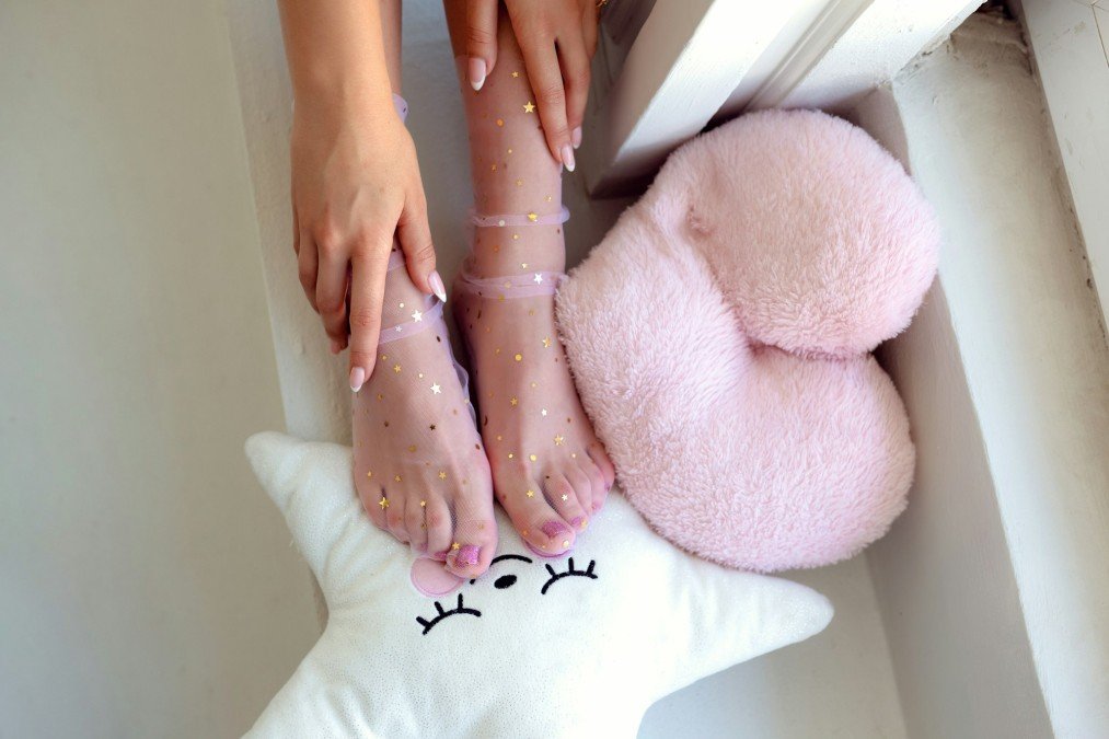 Beautiful groomed woman's feet in the socks with stars