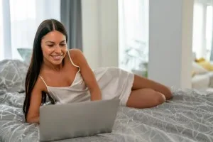 Beautiful woman posing in front of a web camera, working as a sexual model. Online flirting concept