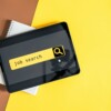 Top view of digital tablet with search job on screen on a yellow background.